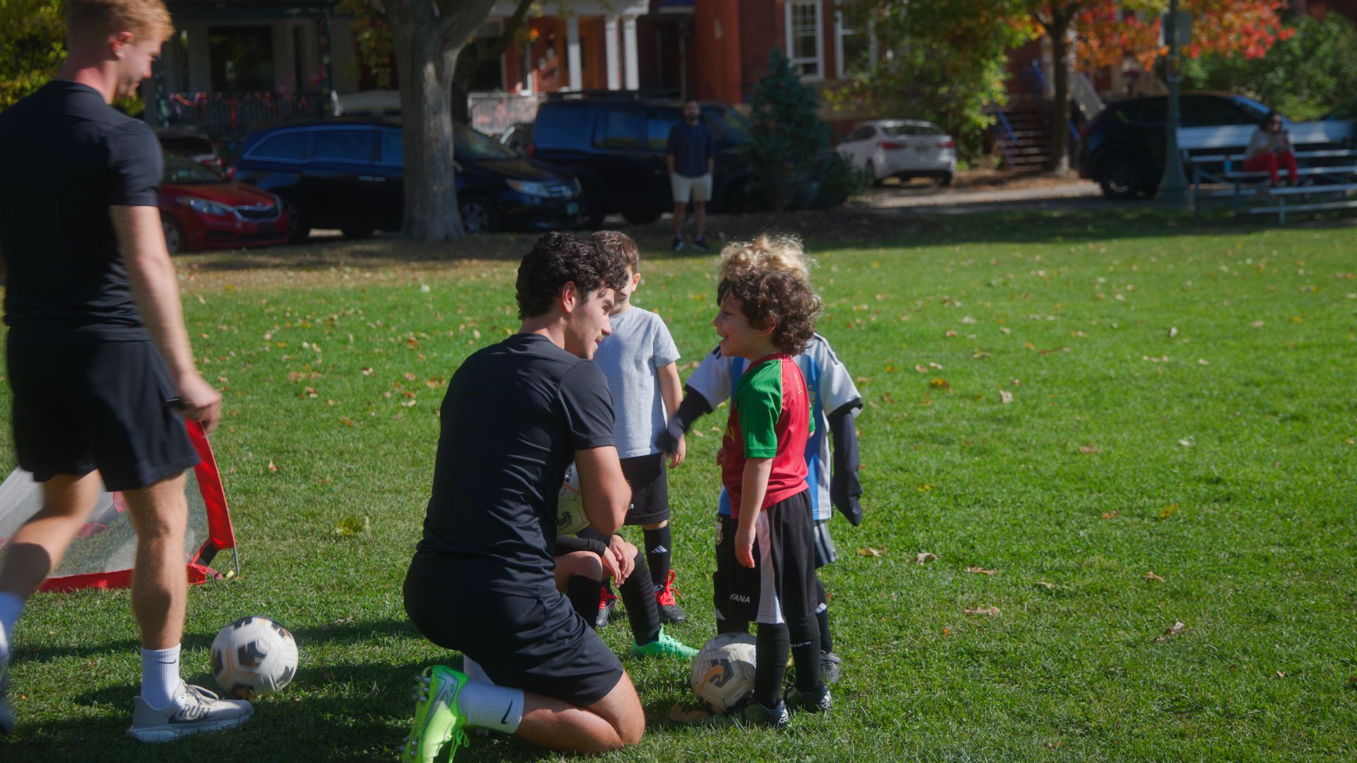 Toddlers aged 2-3 exploring soccer with a coach and parent support